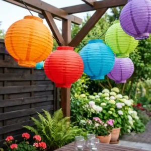 3-gartendeko lampion lichterkette bunt hanging between trees during a sunny day.